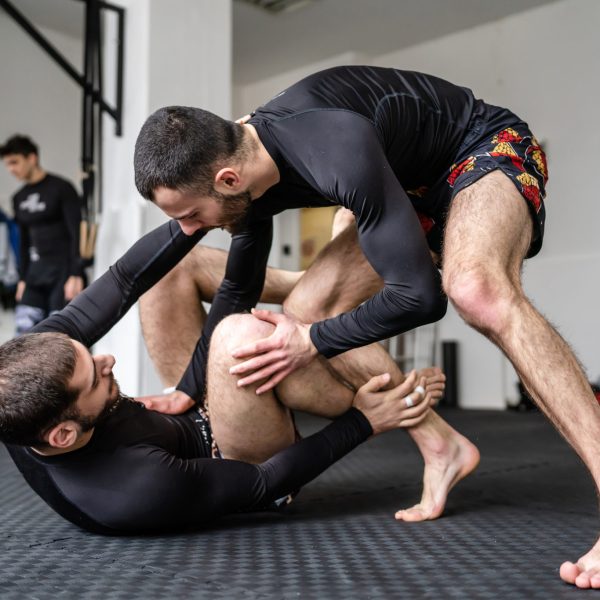 group of people at brazilian jiu jujitsu bjj grappling or luta livre training two men drilling or demonstrate technique or sparring